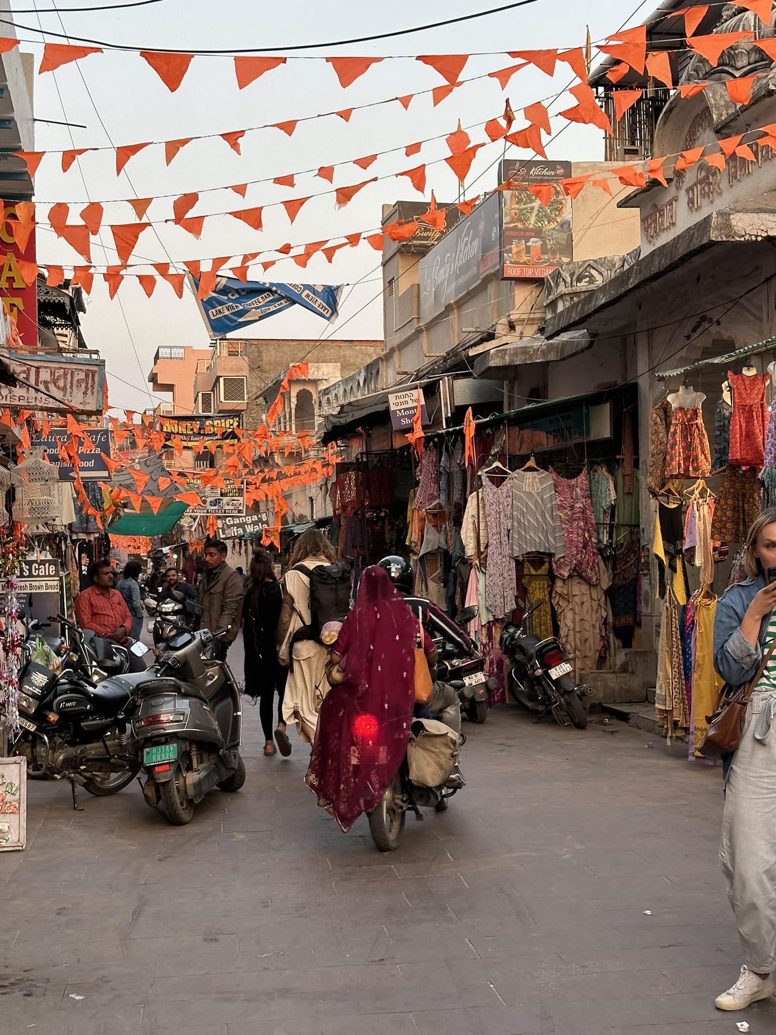 Bazar w Indiach z flagami, ludźmi i skuterami