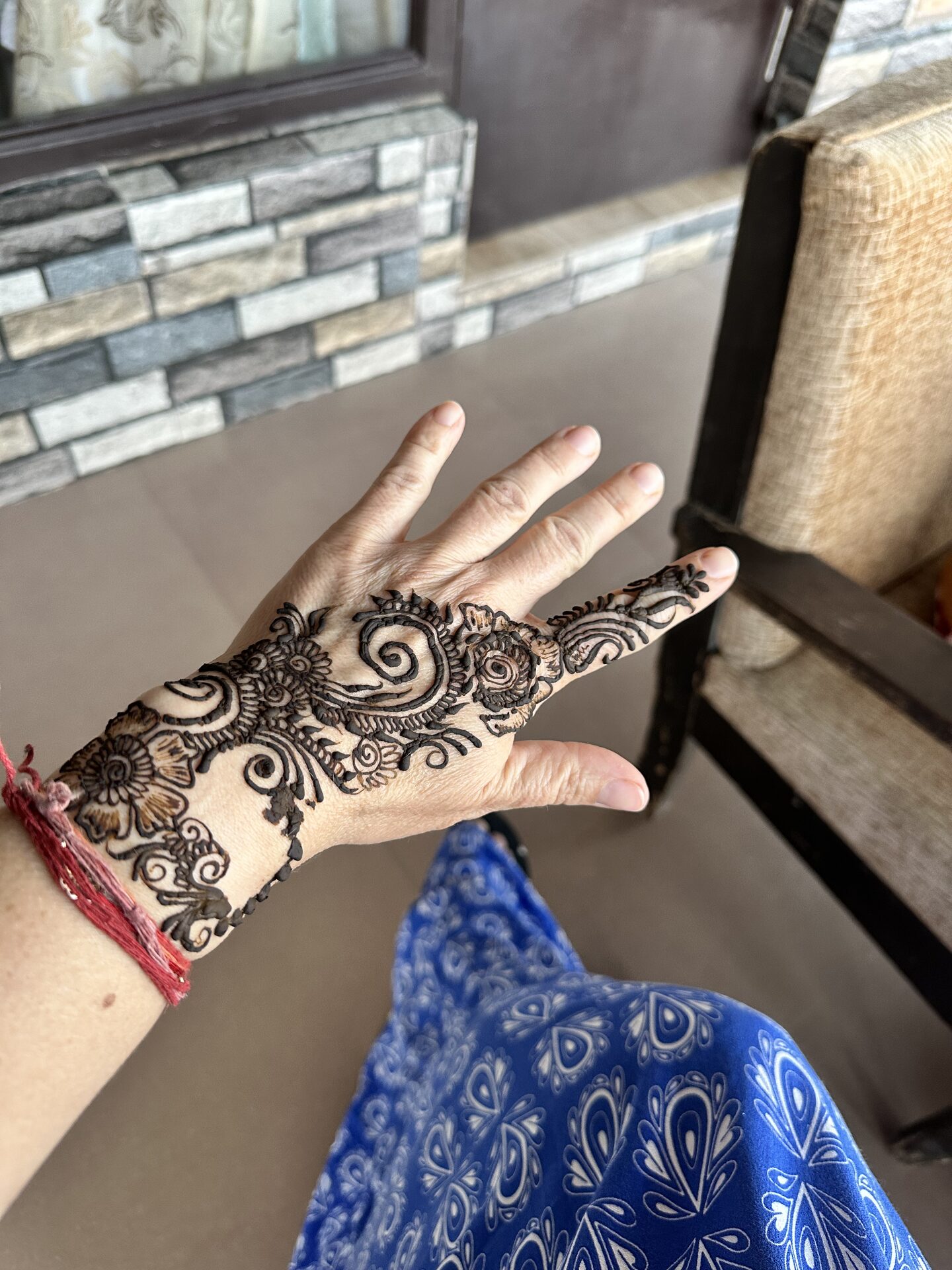 Dłoń kobiety ozdobiona tradycyjnym indyjskim wzorem mehndi henną