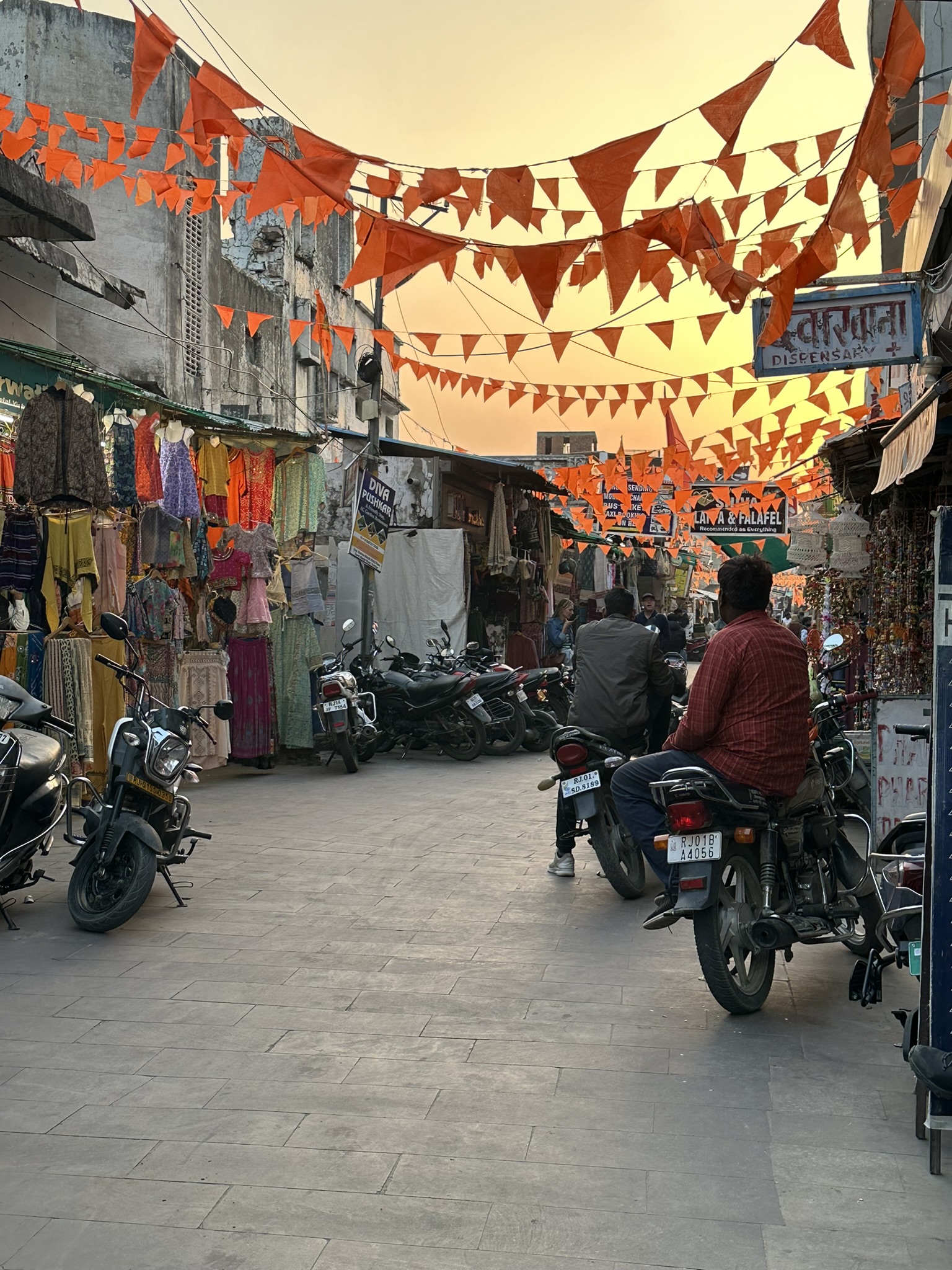 Bazar w Pushkar z pomarańczowymi flagami i kolorowymi ubraniami